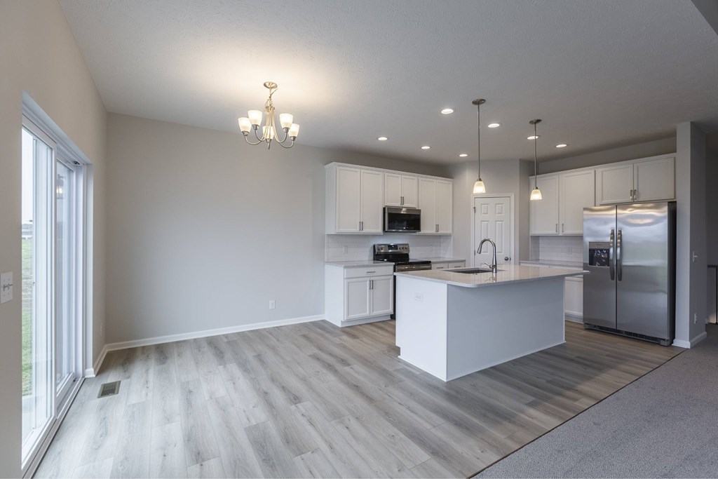 A modern kitchen with a large island and stainless steel appliances.