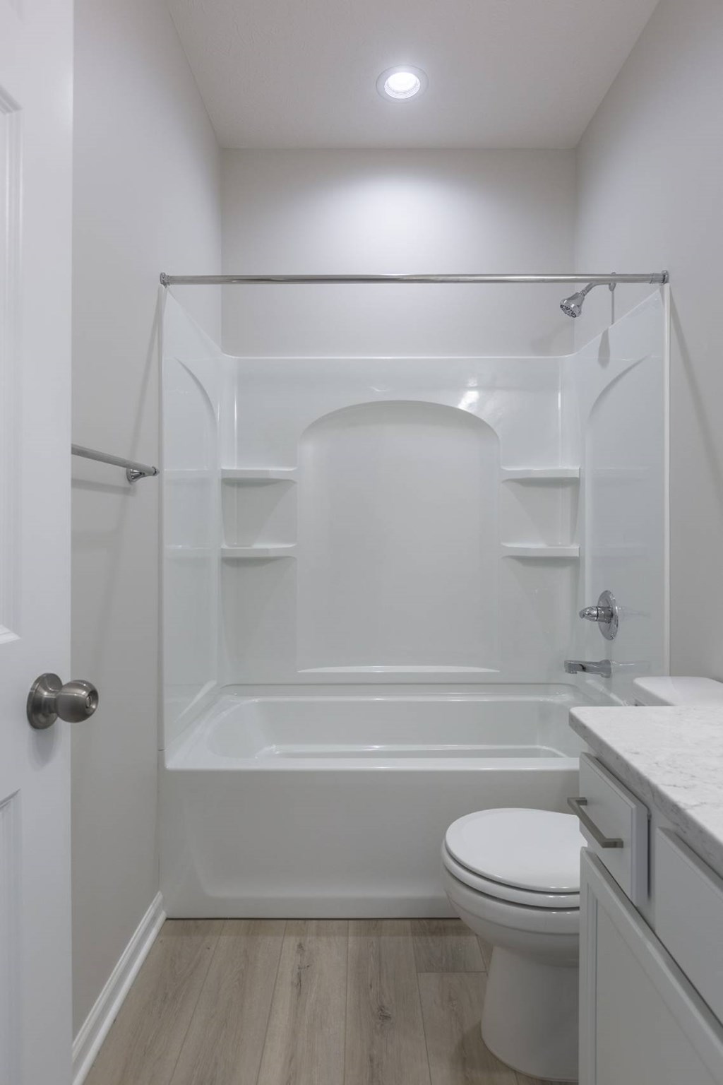 A white bathroom with a toilet, sink, and bathtub.