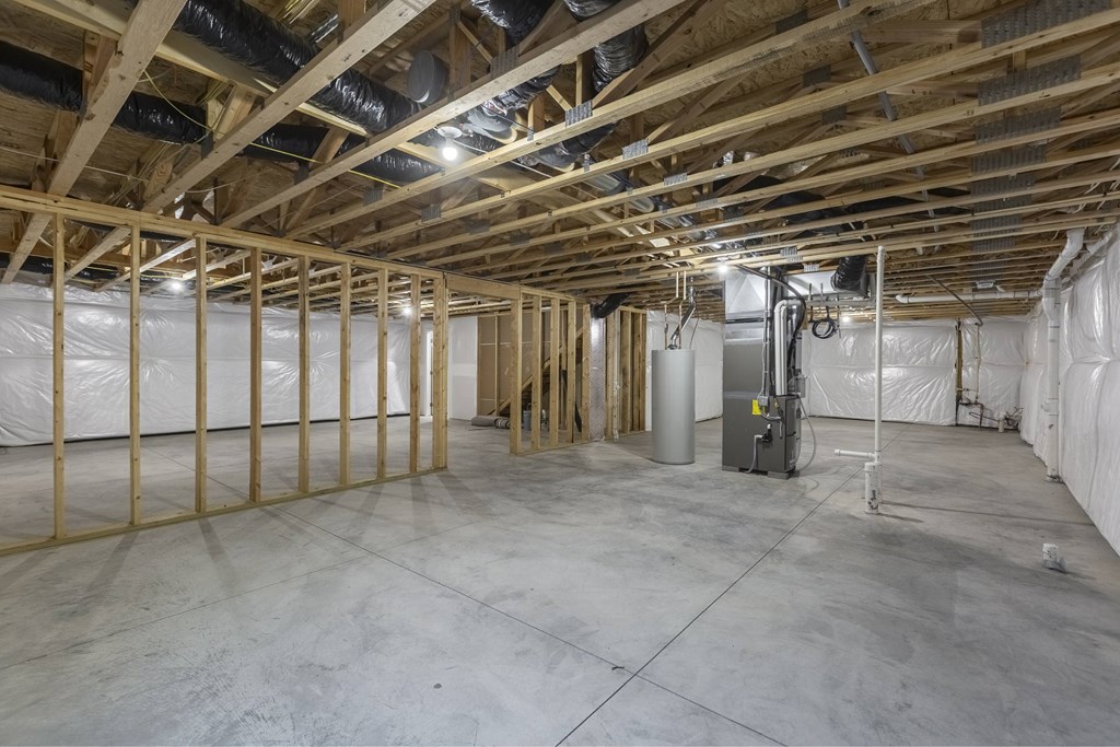A large, empty room with wooden beams and a concrete floor.