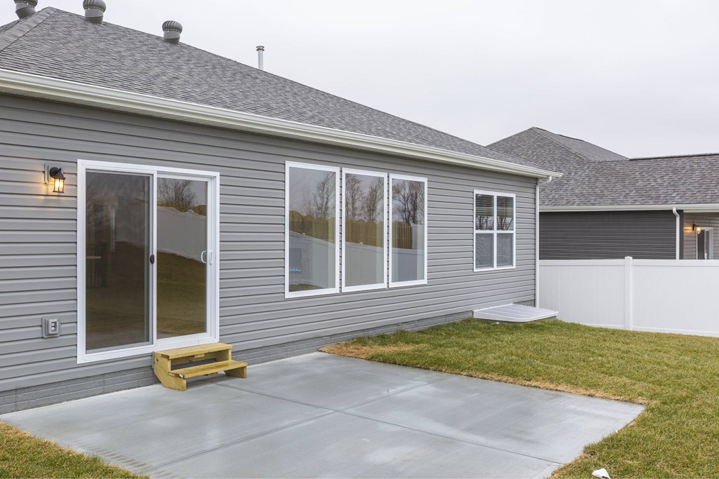 A grey house with a white fence and a grey roof.