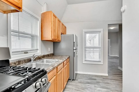 A kitchen with wooden cabinets and a stainless steel stove.
