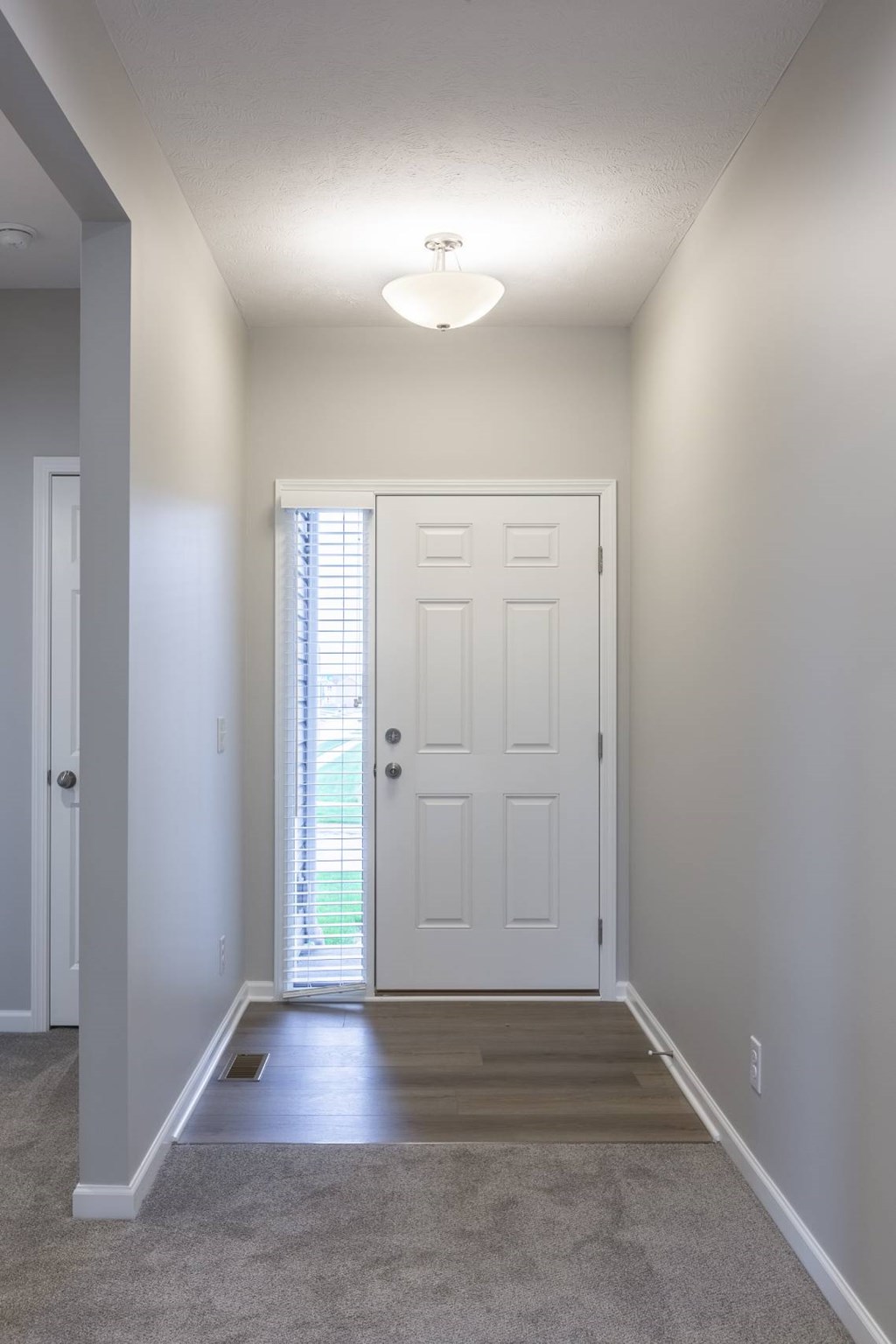 A white door is in the middle of a hallway.