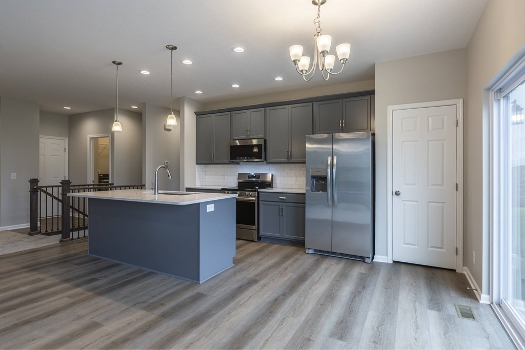 A modern kitchen with a large island and stainless steel appliances.