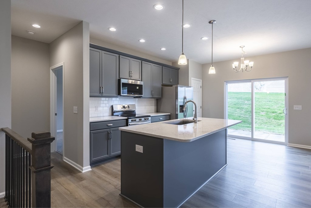 A modern kitchen with dark wood floors and a large island.