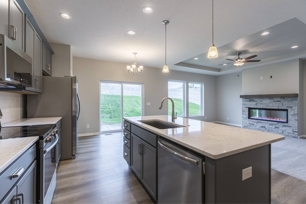 A modern kitchen with a large island and a fireplace.