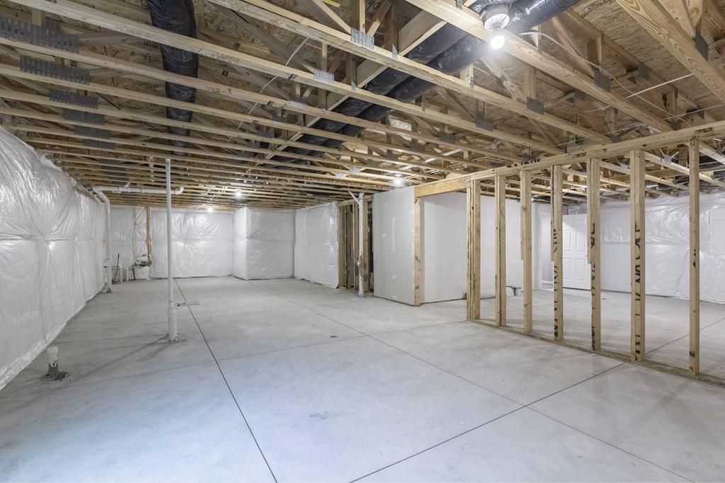 A sparsely furnished room with wooden beams on the ceiling.
