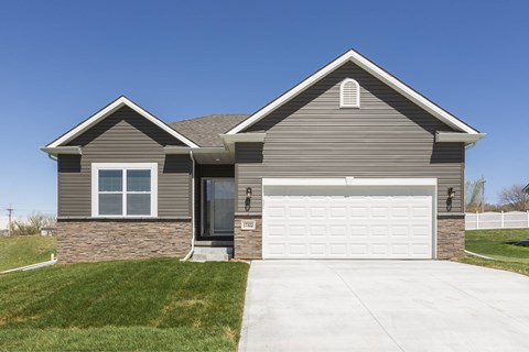 A two-story house with a garage door and a driveway.