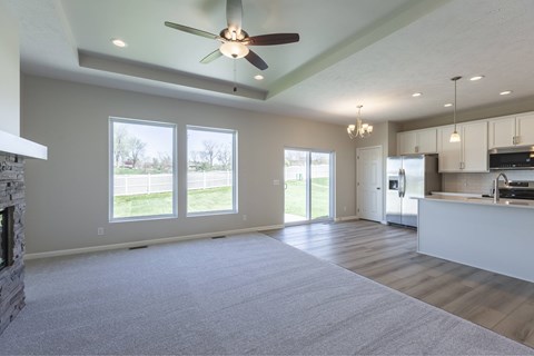 A spacious living room with a fireplace and a ceiling fan.