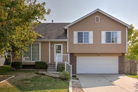 A house with a brown exterior and a white garage door.