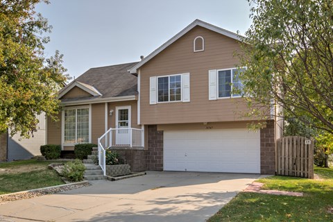 A house with a brown exterior and a white garage door.