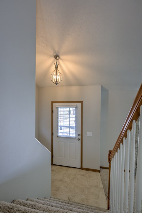 A staircase with a light hanging above it.