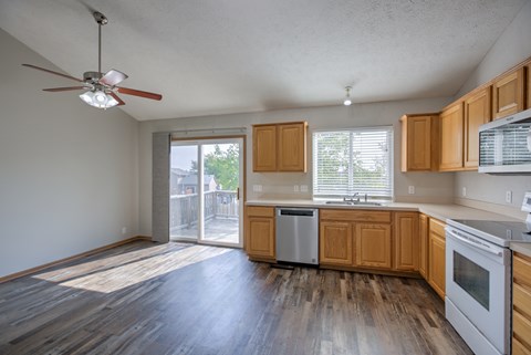 A kitchen with wooden cabinets and a fan on the ceiling.