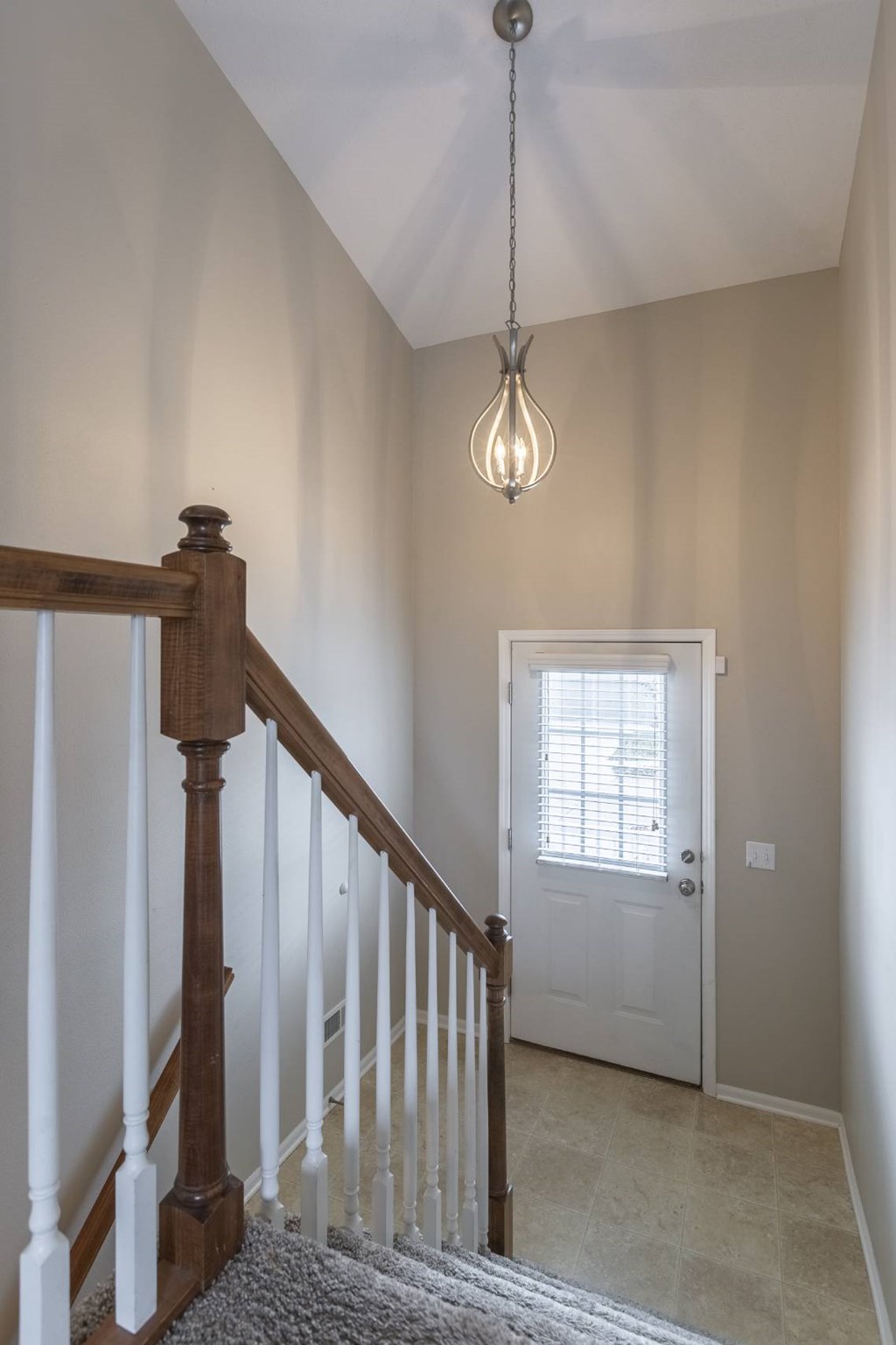 A light hanging from a ceiling in a room with a staircase.