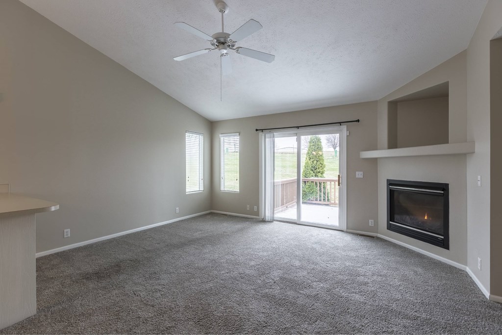 A spacious living room with a fireplace and sliding glass doors.
