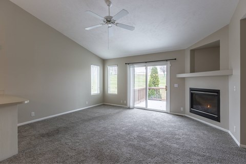 A spacious living room with a fireplace and sliding glass doors.