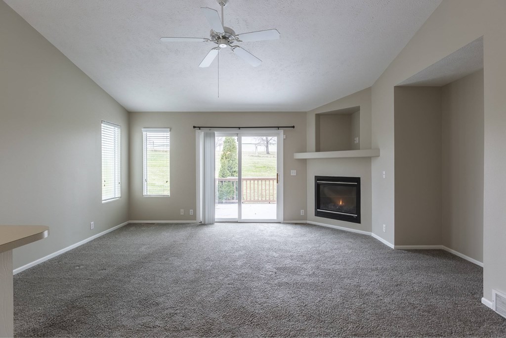 A living room with a fireplace and sliding glass doors.