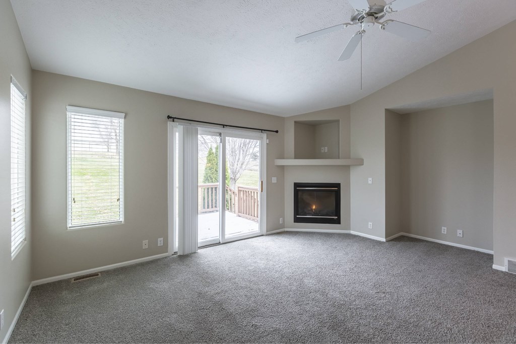 A living room with a fireplace and sliding glass doors.
