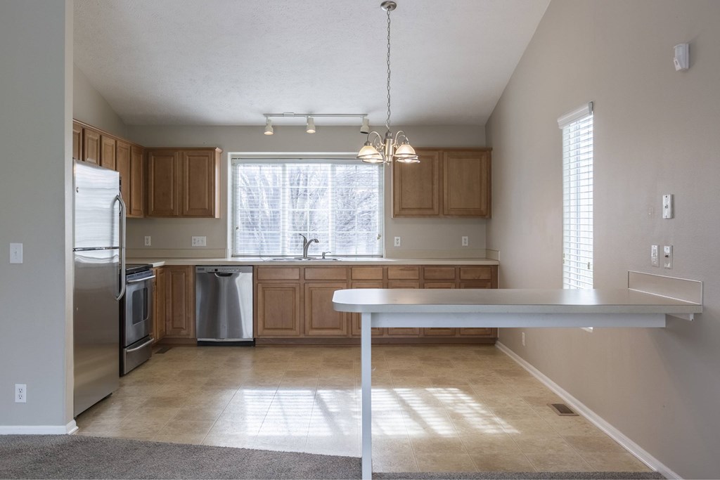 A kitchen with a white fridge and wooden cabinets.