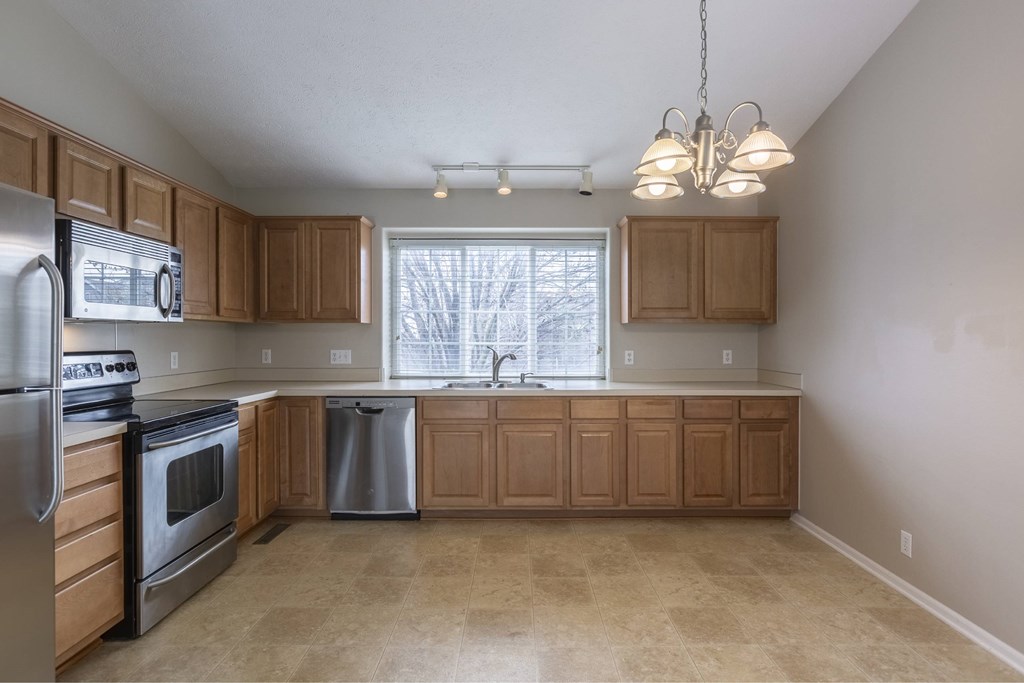 A kitchen with wooden cabinets and stainless steel appliances.