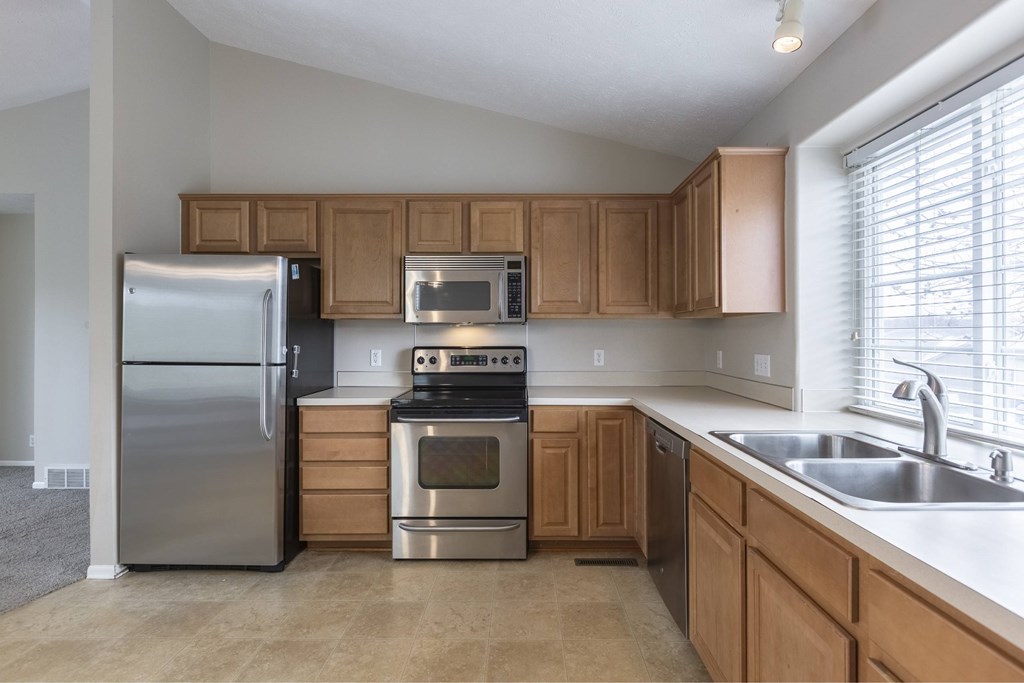 A kitchen with wooden cabinets and stainless steel appliances.