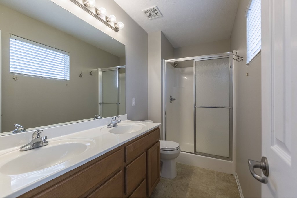A bathroom with a white sink, toilet, and shower.