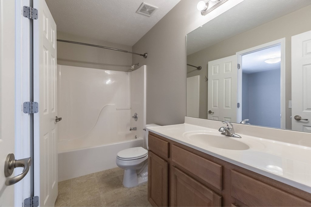 A white bathroom with a toilet, sink, and bathtub.