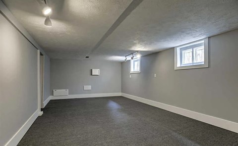 A room with grey carpet and white walls.