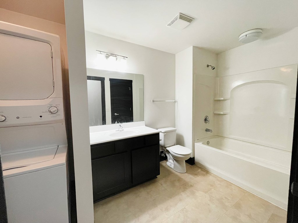 A white bathroom with a washer and dryer.