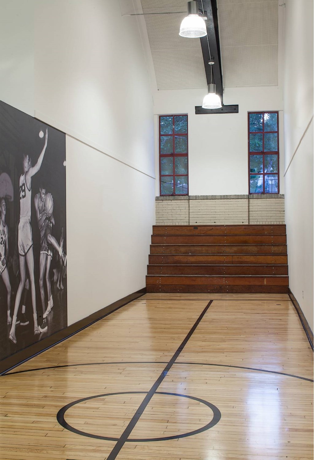 A basketball court with a large painting on the wall.