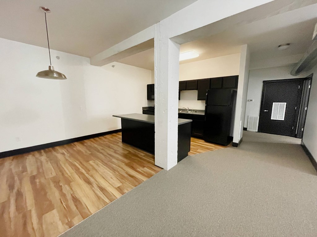 A room with a grey carpet and wooden floors.
