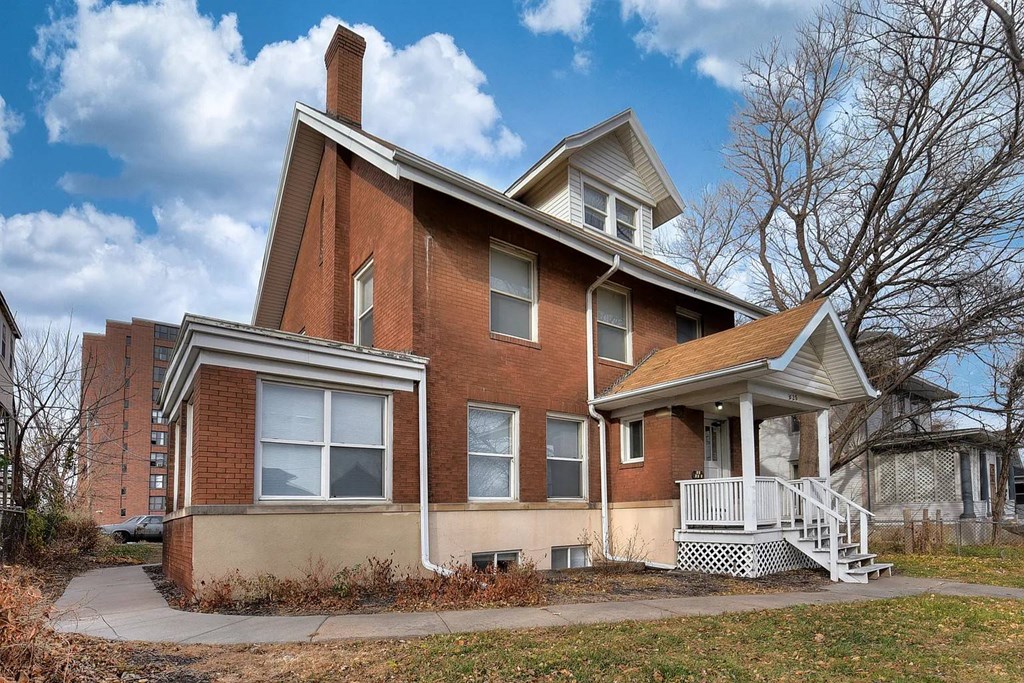 A red brick house with a white porch.
