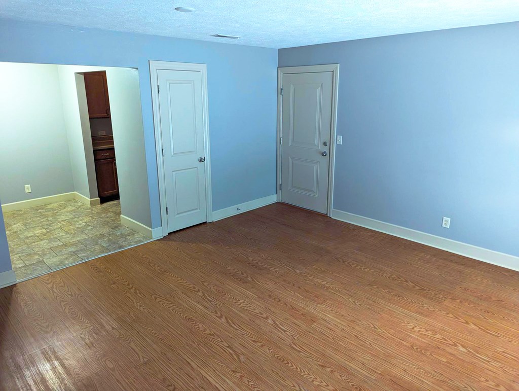 A room with two doors and a wooden floor.