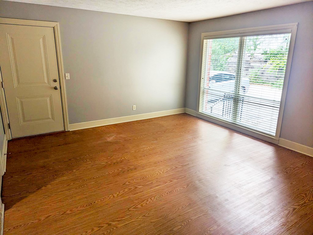 A room with a wooden floor and a sliding glass door.