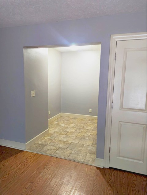 A room with a tiled floor and a white door.