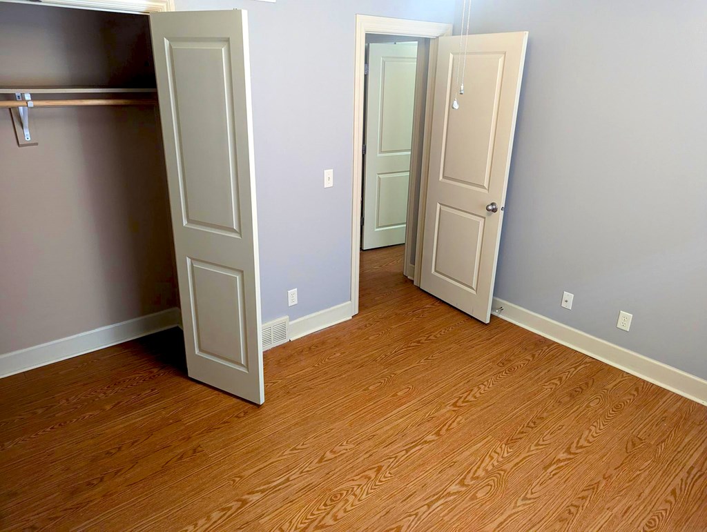 A room with two doors and a wooden floor.