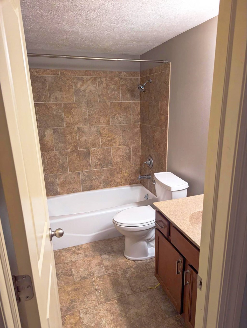 A bathroom with a toilet, sink, and tiled shower.