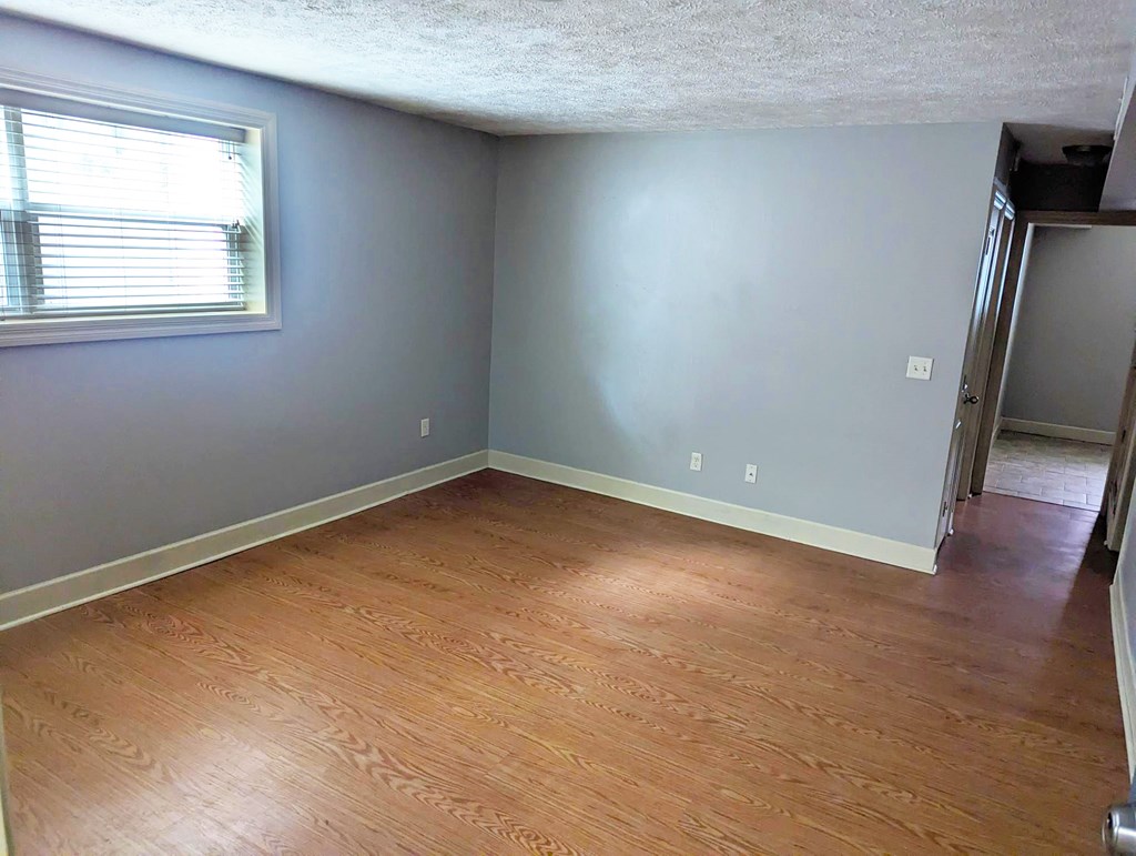 A room with wooden flooring and a window.