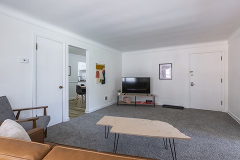 A living room with a brown couch and a white table.