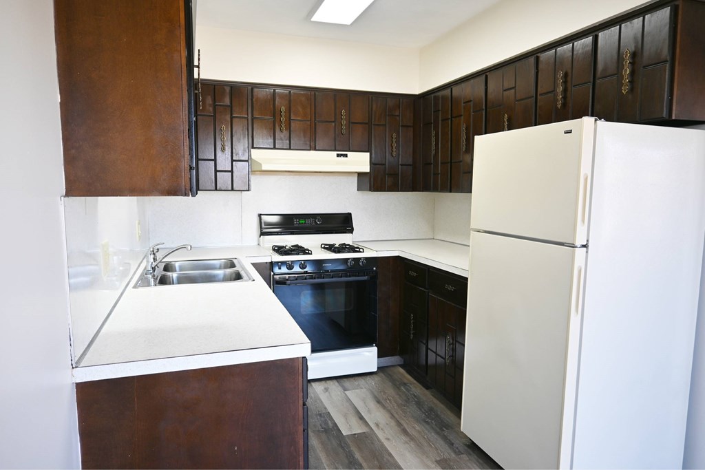 A kitchen with a white fridge and black cabinets.