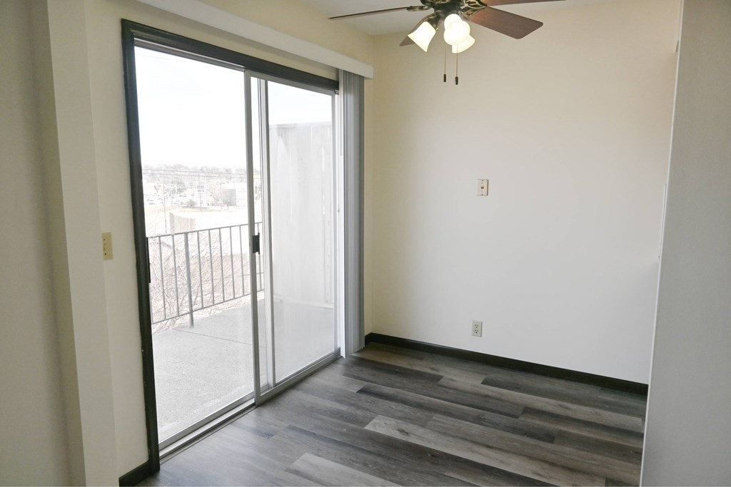 A room with a sliding glass door leading to a balcony.
