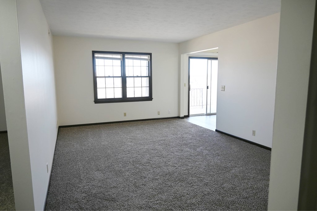 A room with a carpeted floor and a window.