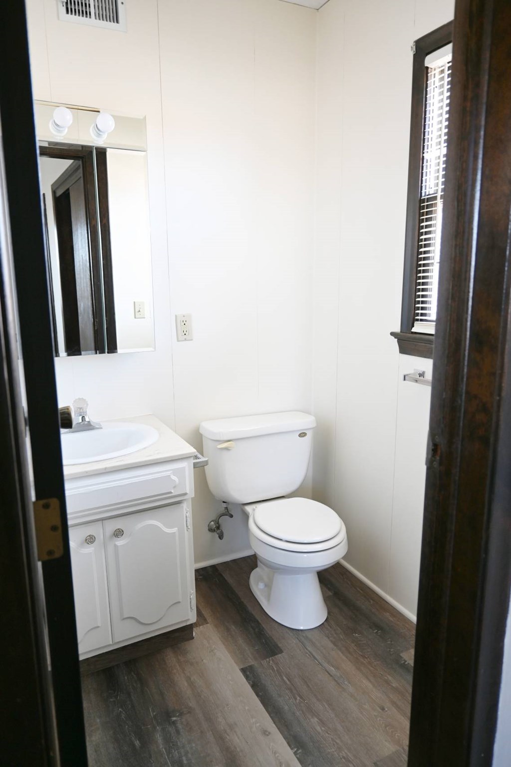 A white toilet sits next to a sink in a bathroom.