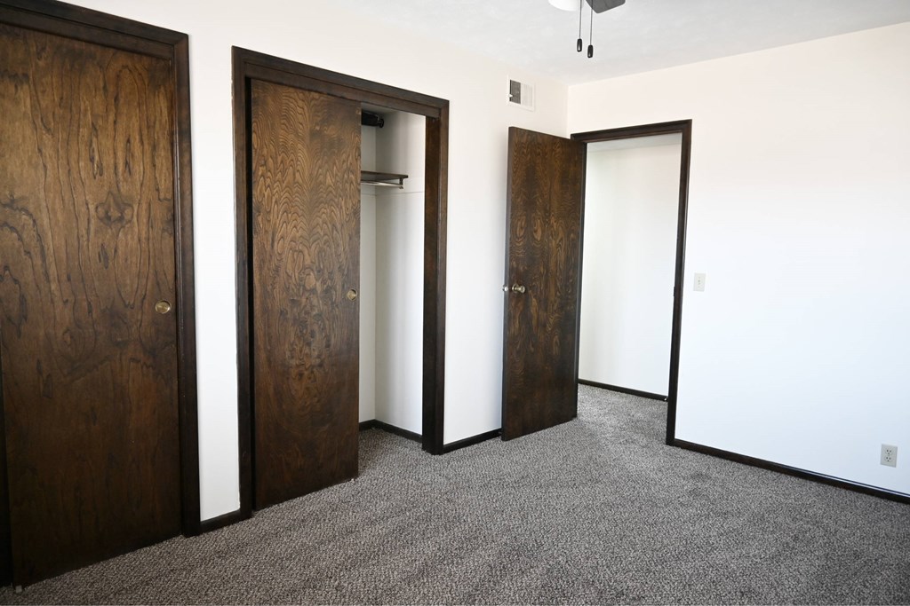Three doors are in a white room.
