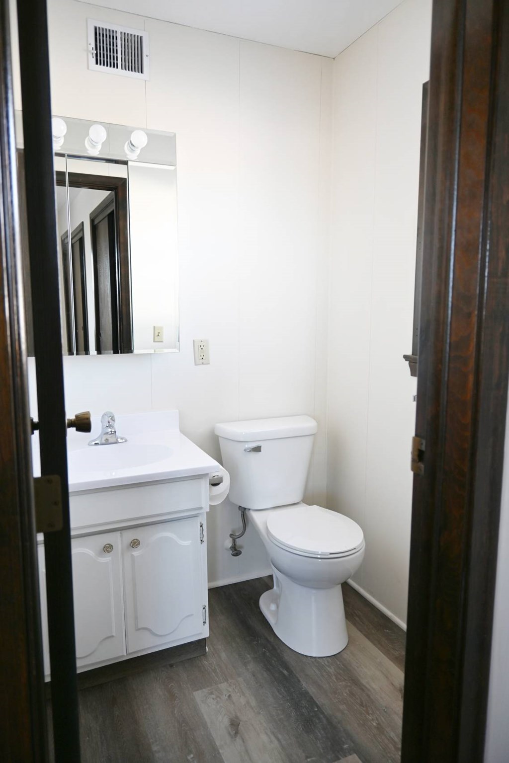 A white toilet sits next to a sink in a small bathroom.