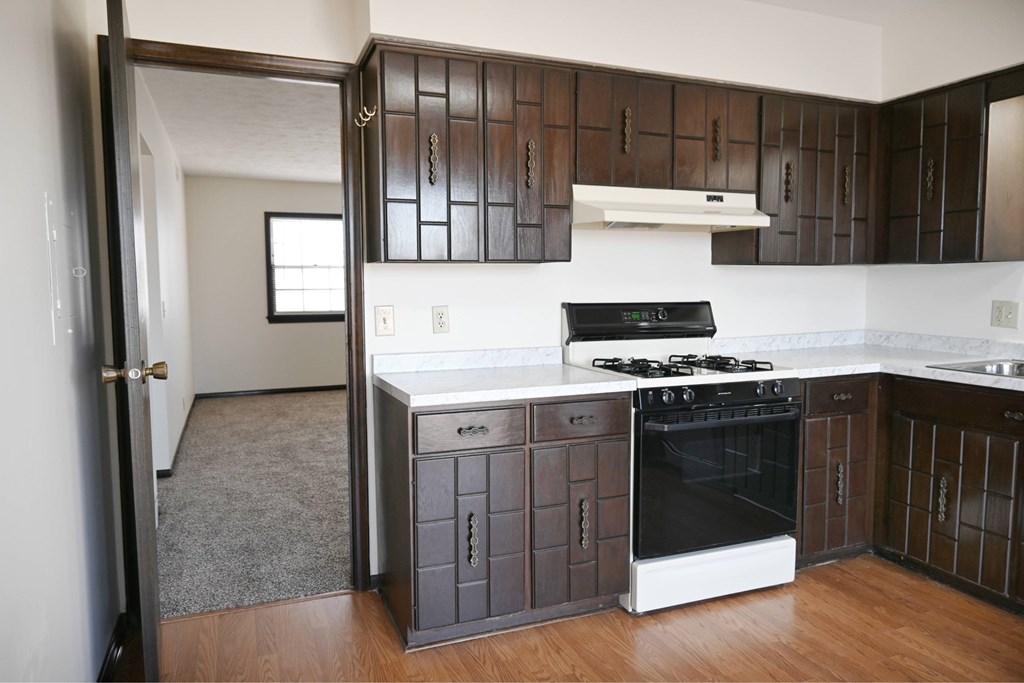 A kitchen with a black oven and cabinets.