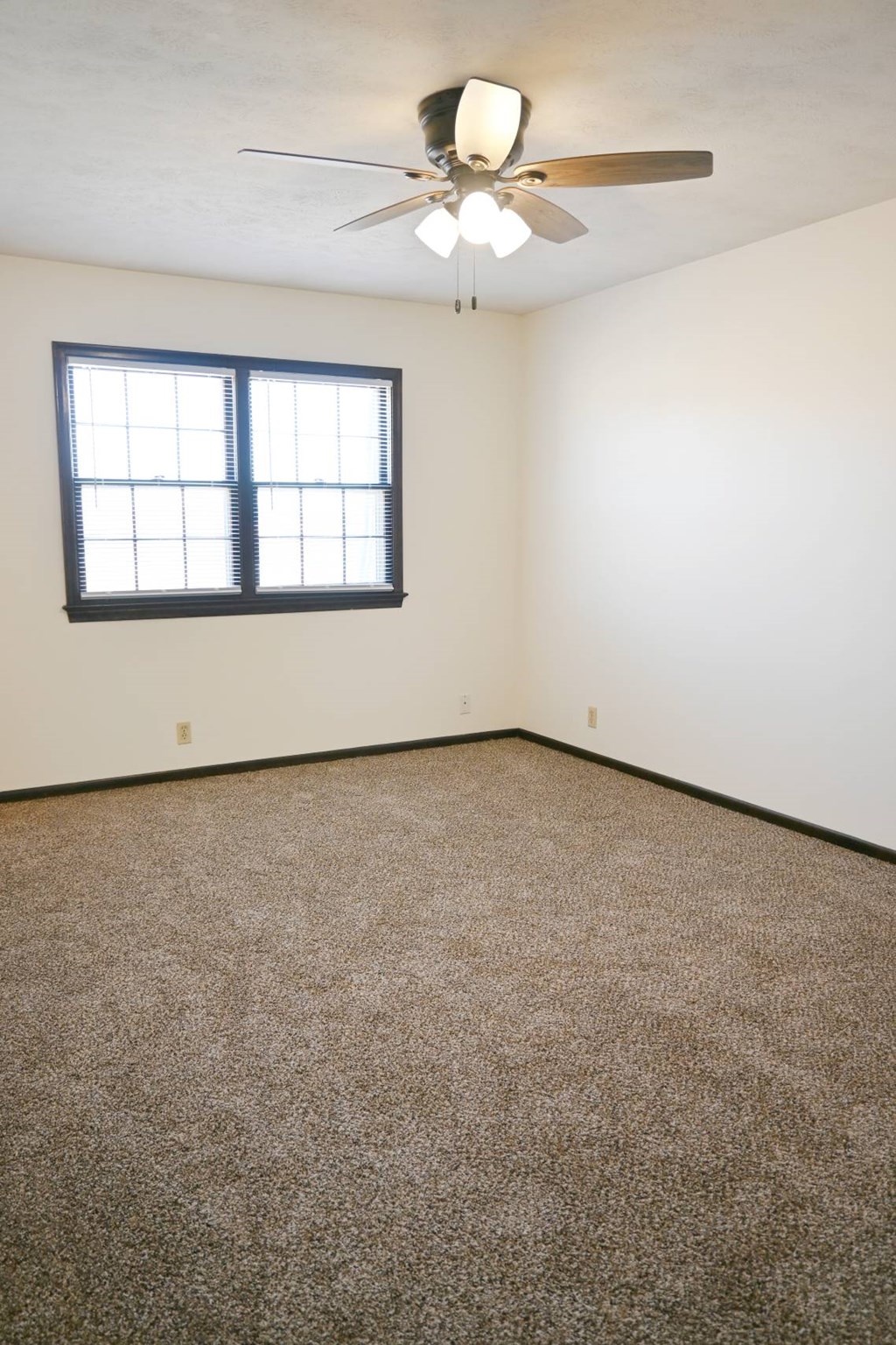 A room with a ceiling fan and a window.
