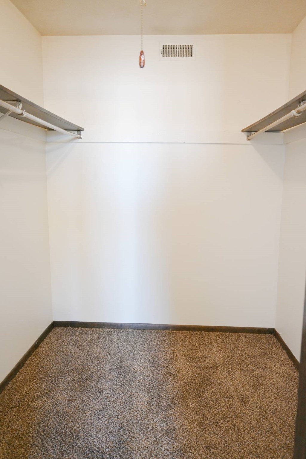 A carpeted room with a white wall and a white ceiling.