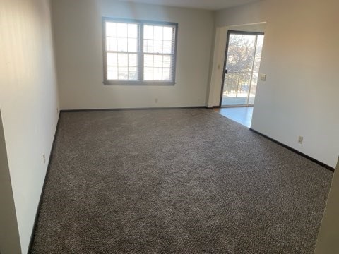 A room with a carpeted floor and a window.