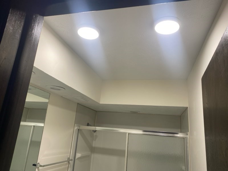 A bathroom with a mirror and a light on the ceiling.