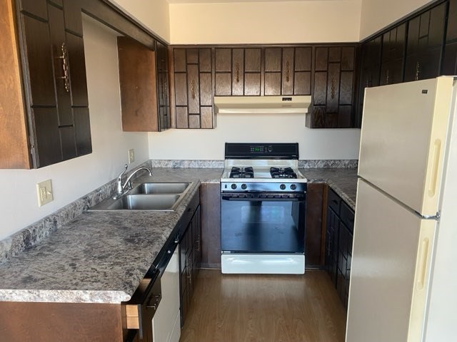 A kitchen with a white refrigerator, a stove, and a sink.